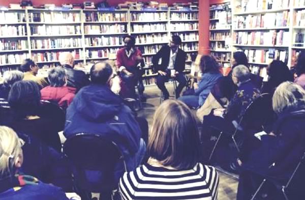 Two men facing an audience answering questions at a bookstore gathering