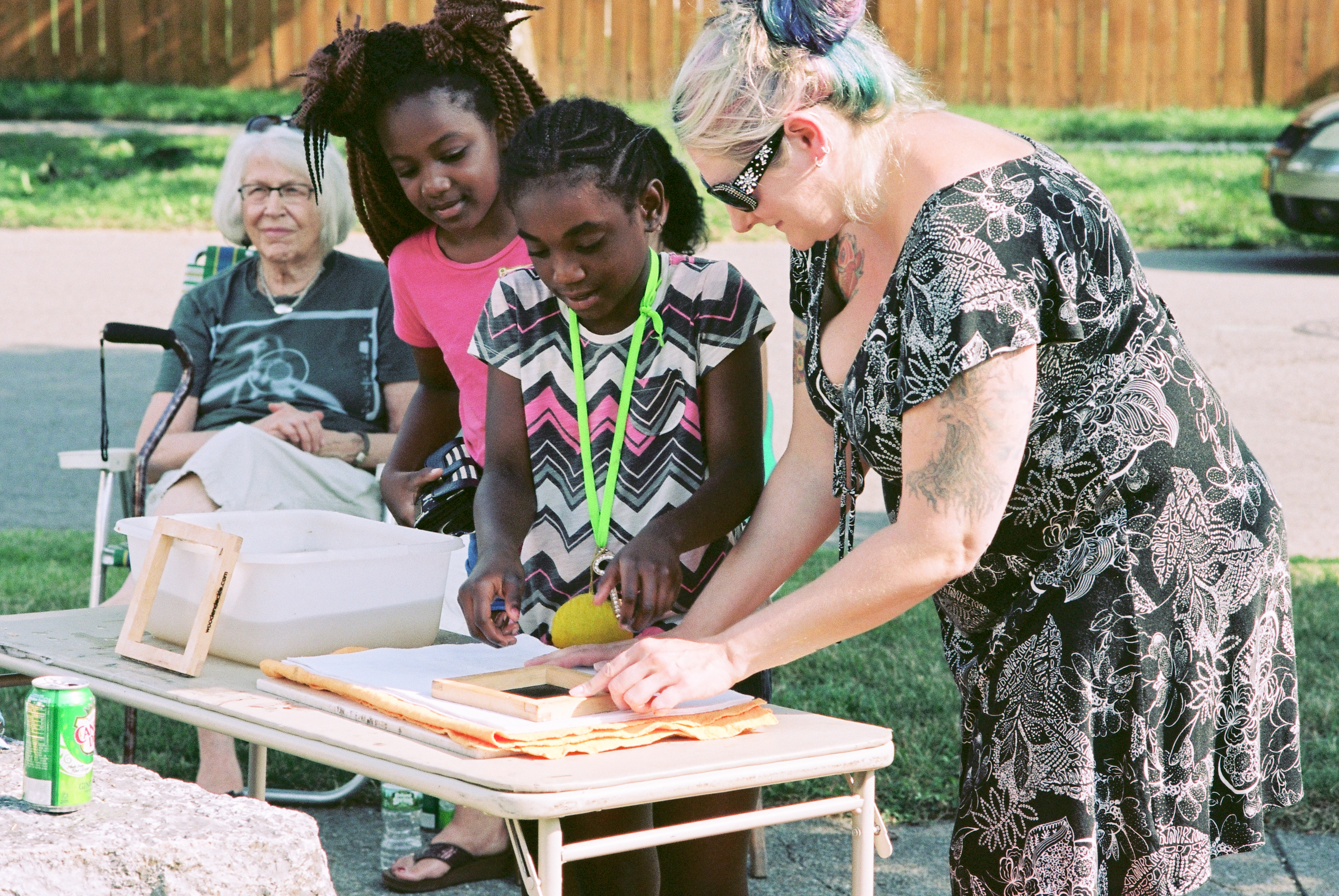 Students and a teacher make seed paper in a community garden