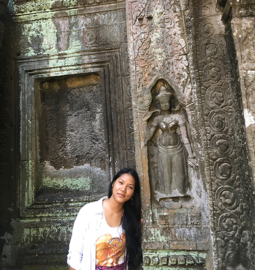 Young woman standing in front of a temple. 