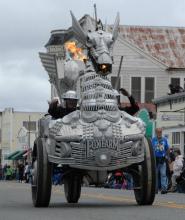 a dragon bicycle sculpture parades down a town's main street