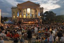 crowd of people sitting and watching evening music concert