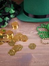 Photo with gold coins, green party beads, a green hat, and black scarf with green four-leaf clovers